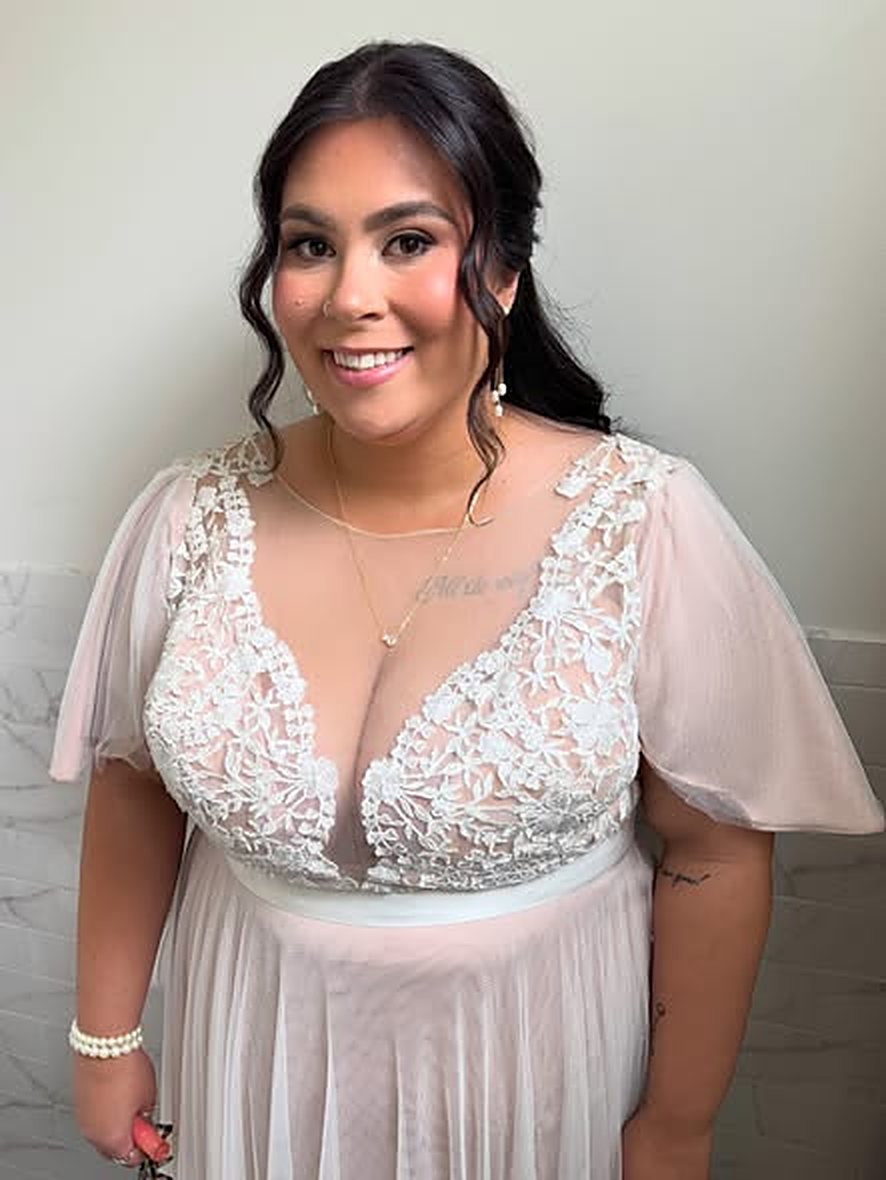 Bride with soft glam makeup and long curls in a lace gown