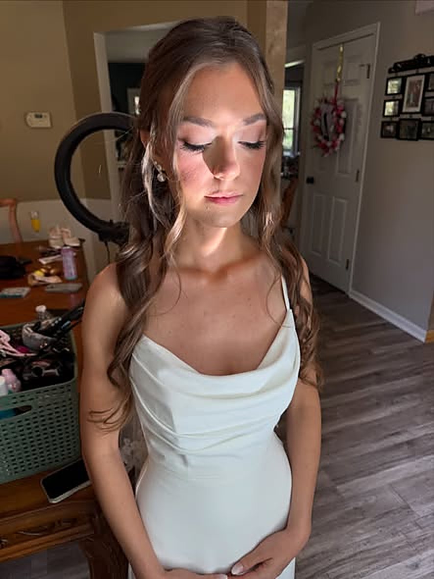 Client in a sage dress getting ready, eyes closed to show soft shimmer