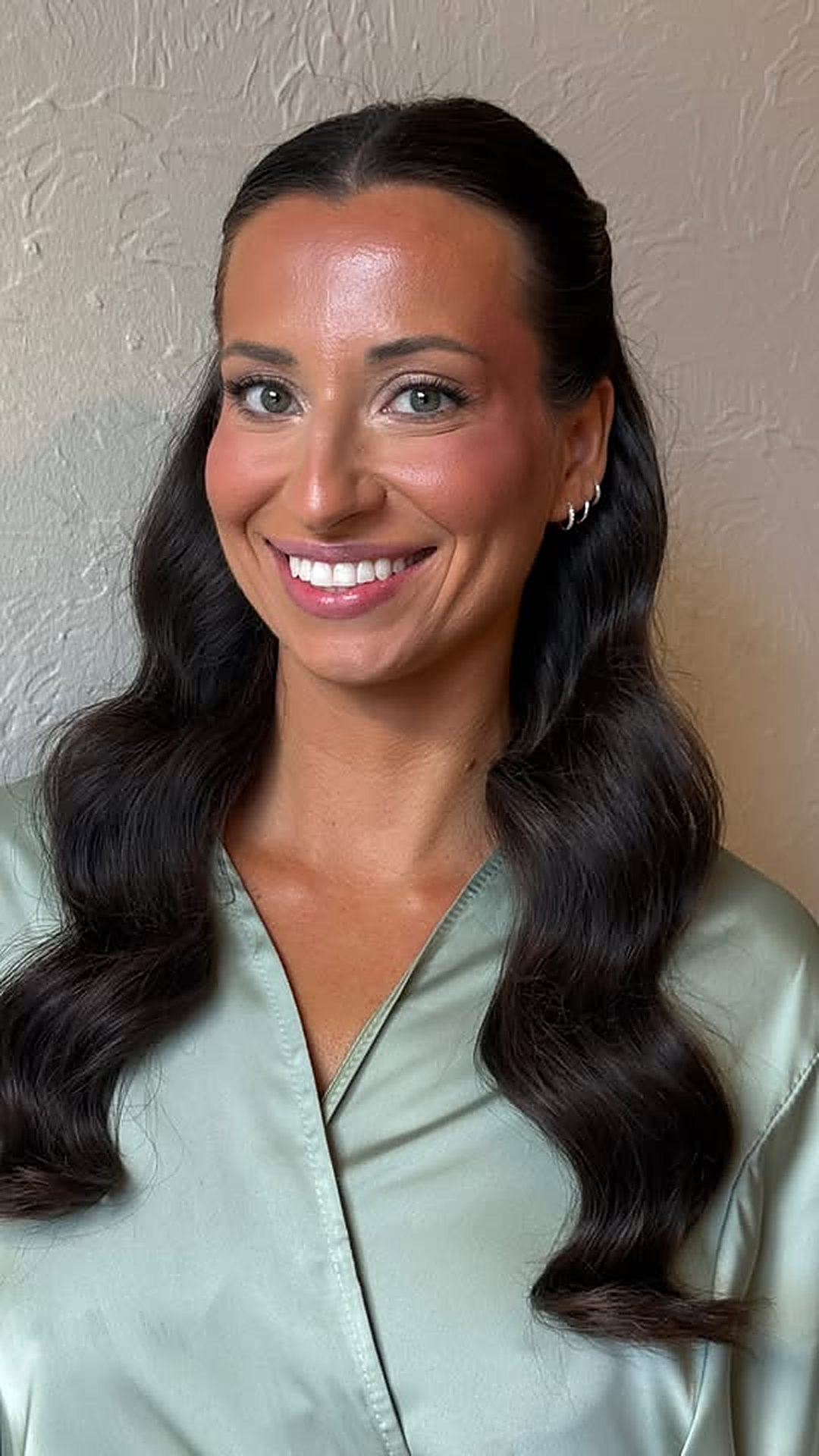 Smiling client with glowy glam and long waves